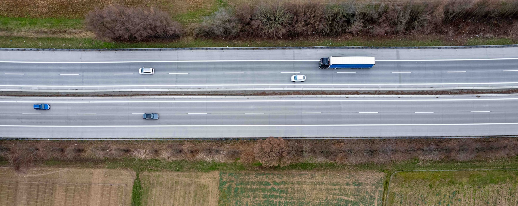 Pemandangan udara truk-truk logistik di jalan tol yang terhubung dalam jaringan armada digital