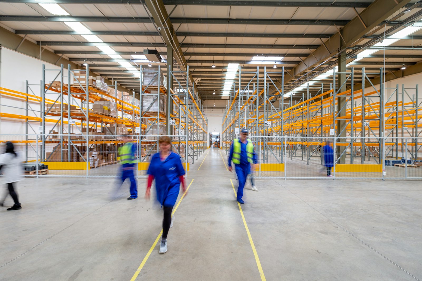 Petugas gudang logistik berjalan di lorong rak saat proses picking barang secara manual sebelum penerapan smart glasses