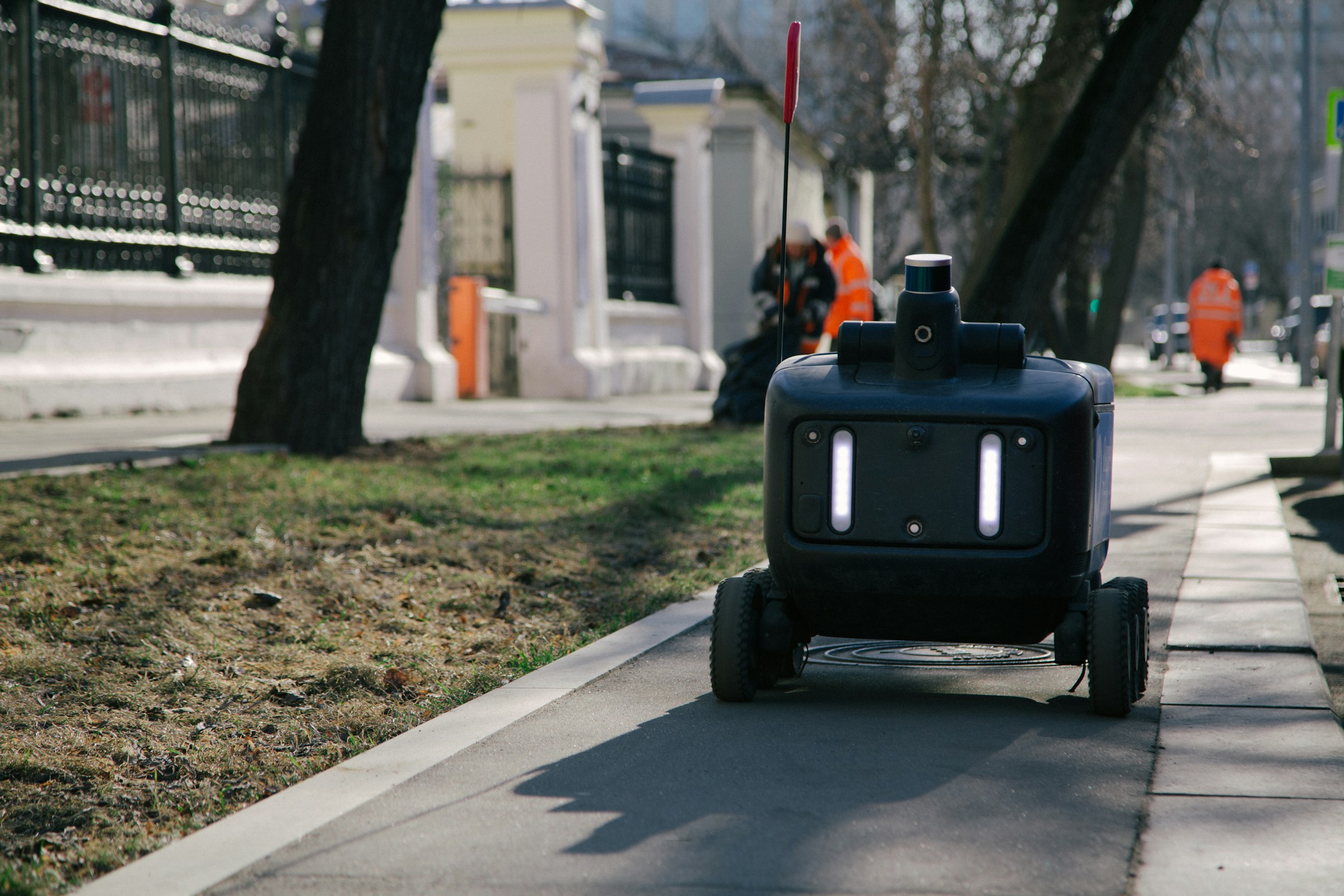 Robot pengantar otonom beroda melaju di trotoar kota untuk layanan pengiriman last-mile