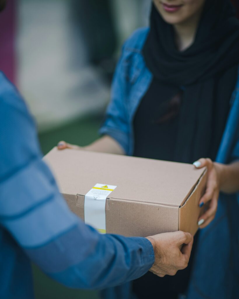Kurir menyerahkan paket sebelum proses pengambilan lewat smart parcel locker untuk last-mile delivery