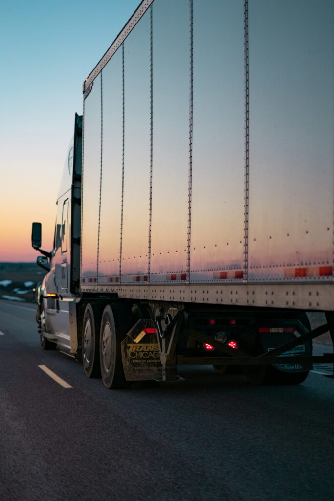 Transportation Management System TMS - truk logistik melaju di jalan raya