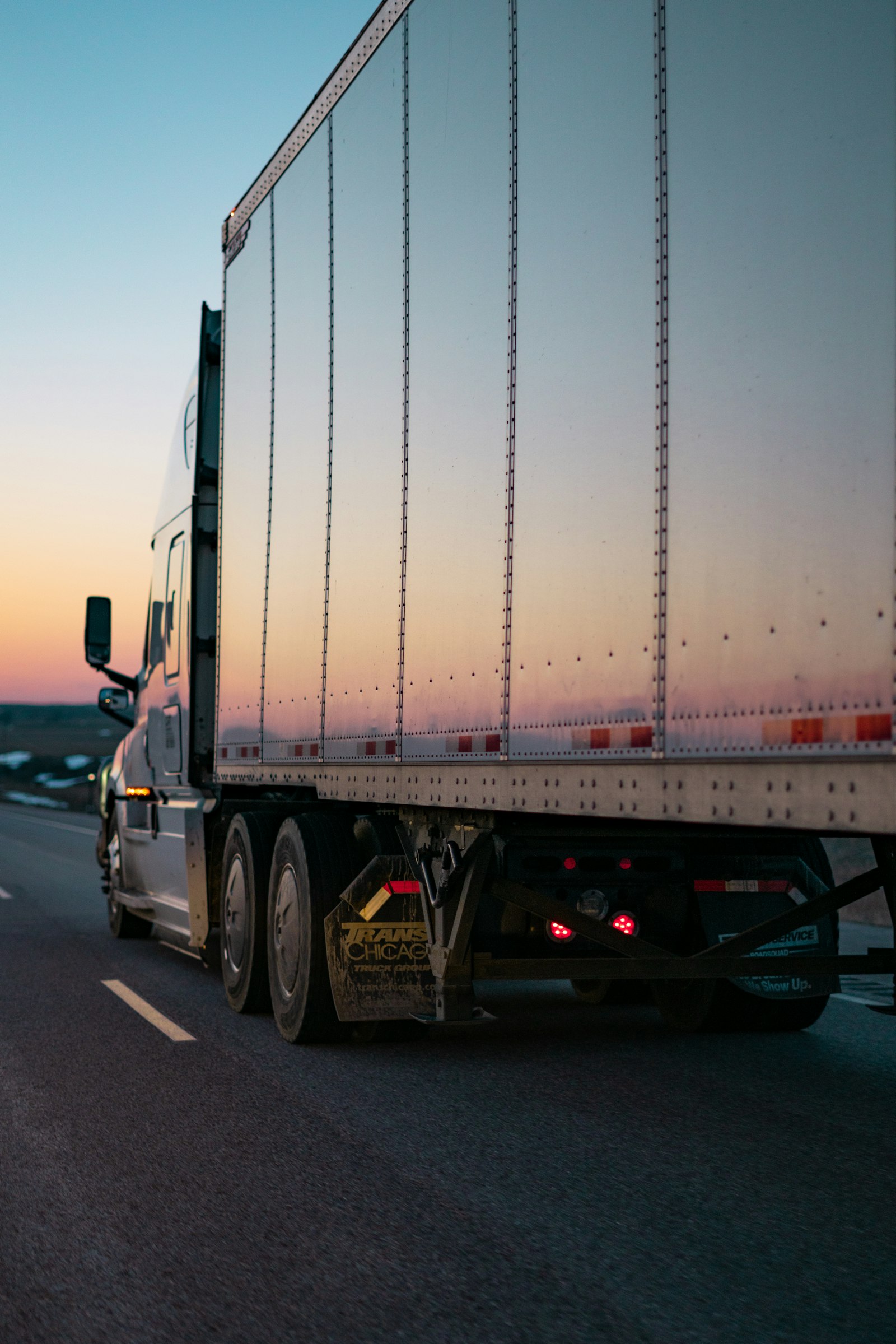 Transportation Management System TMS - truk logistik melaju di jalan raya